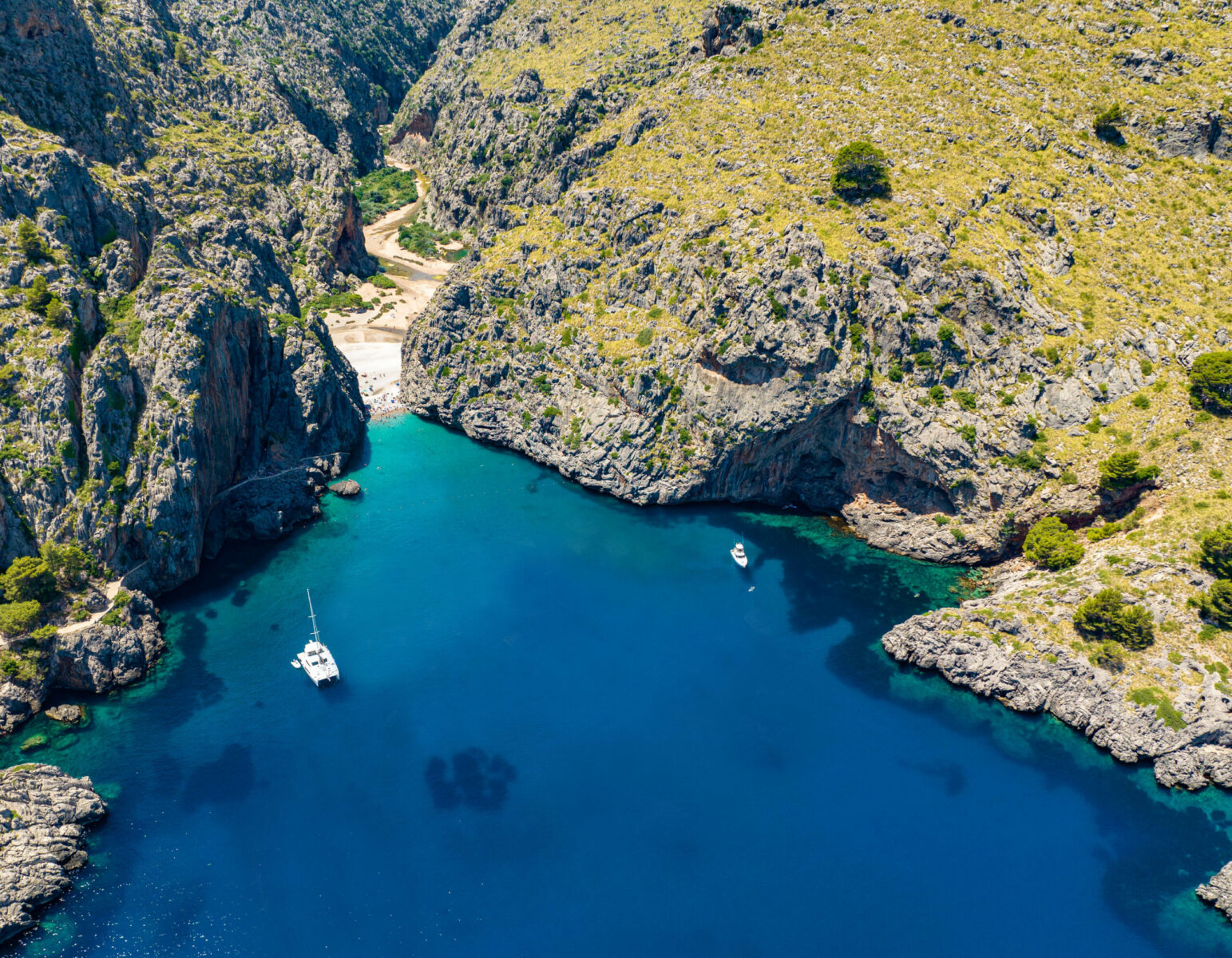 Cala Sa Calobra in Mallorca with a catamaran anchored in the crystal-clear bay